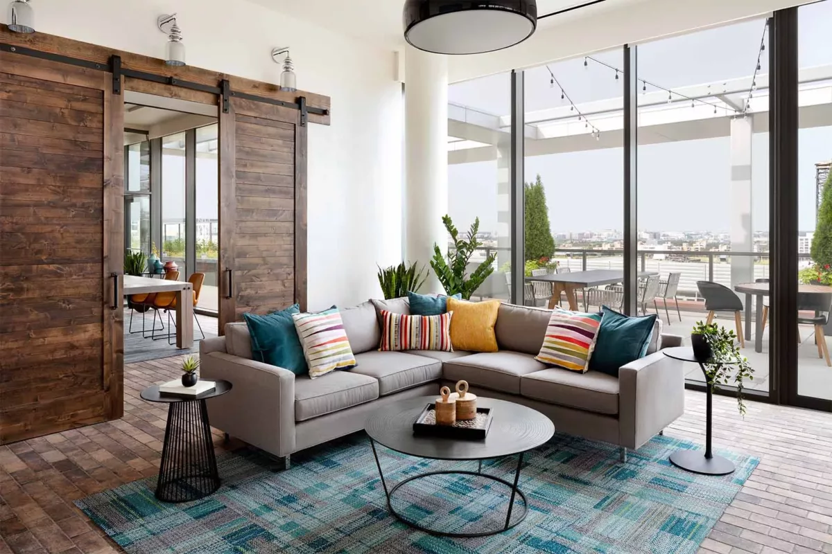 Bright lounge with sofa, accent chairs, coffee table, and large windows.
