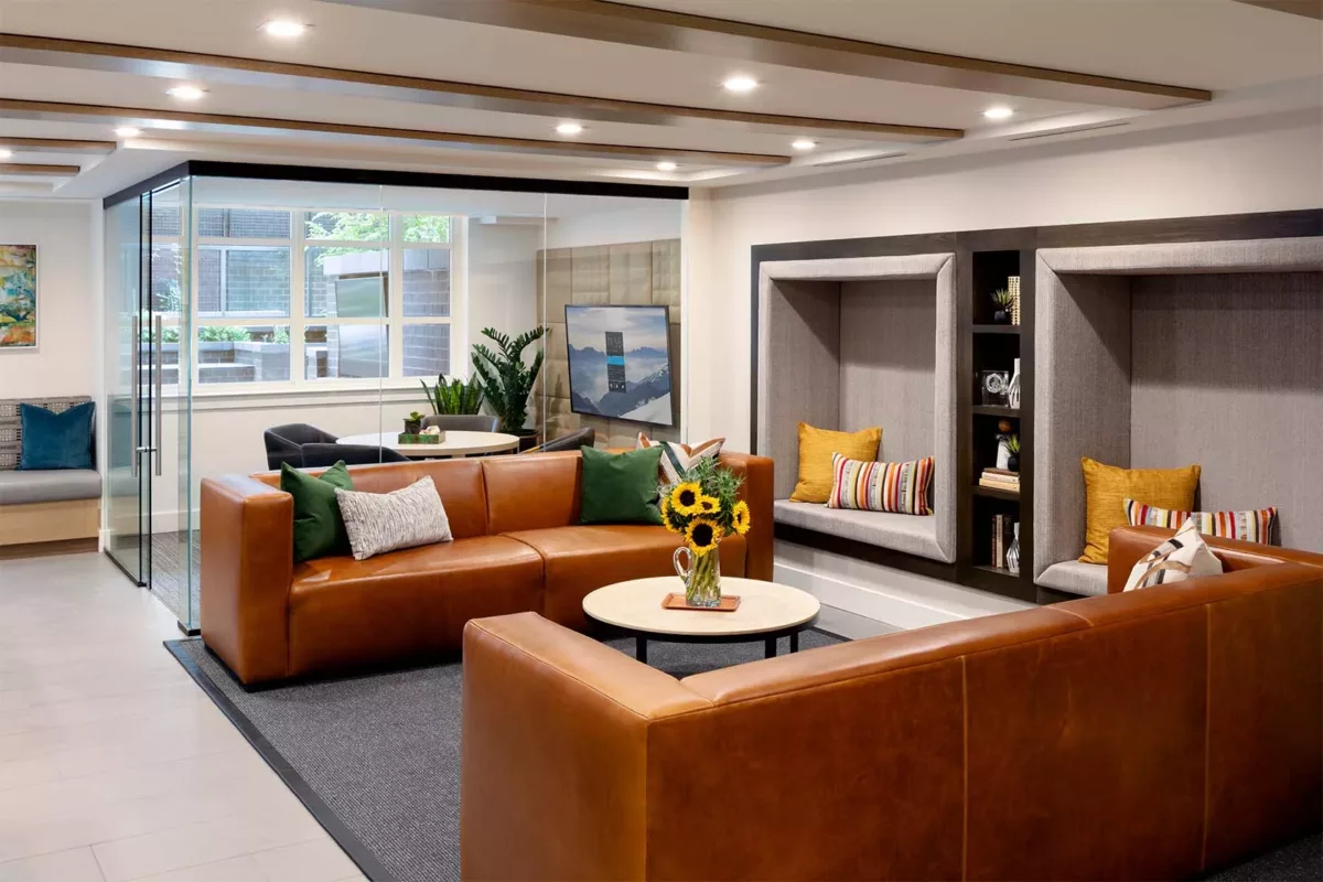 Resident lounge with leather seating, coffee tables, and wall‑mounted television.