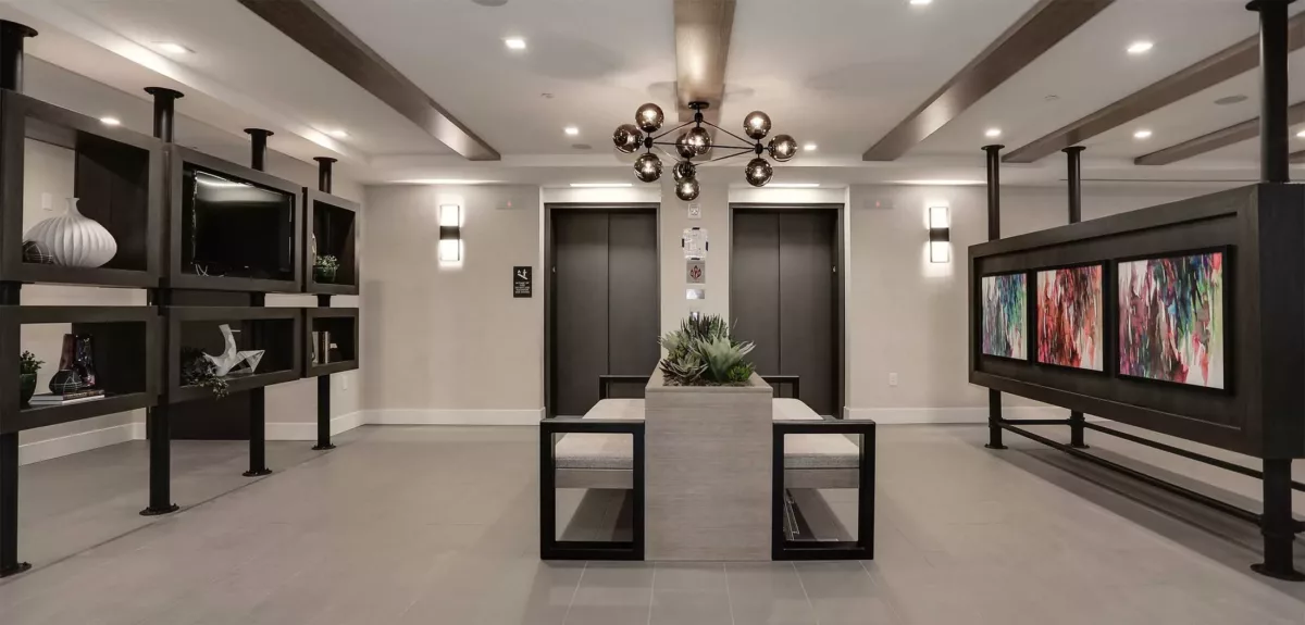 Modern lobby seating area with armchairs, side tables, and decorative lighting.