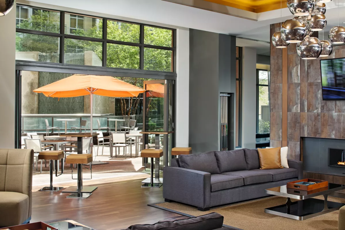 Indoor lounge with sectional seating, accent chairs, and large windows facing patio.