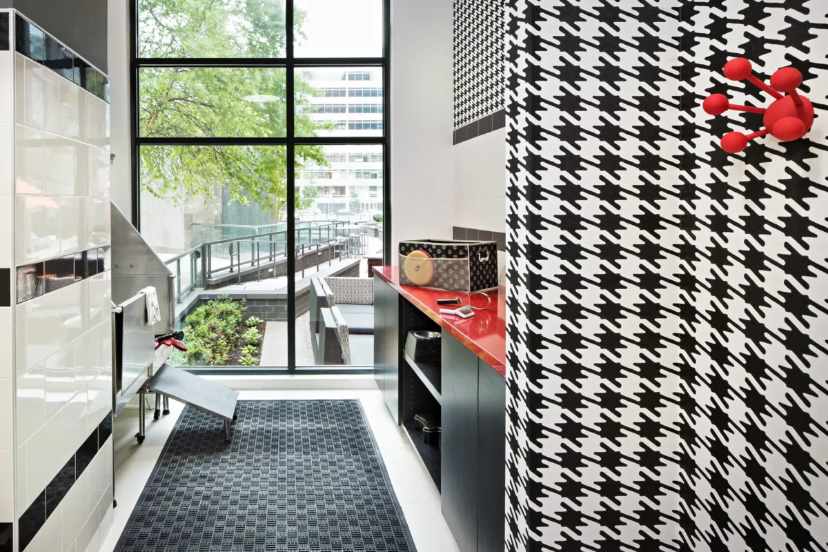 Fitness center with treadmills, weight equipment, mirrors, and patterned accent wall.