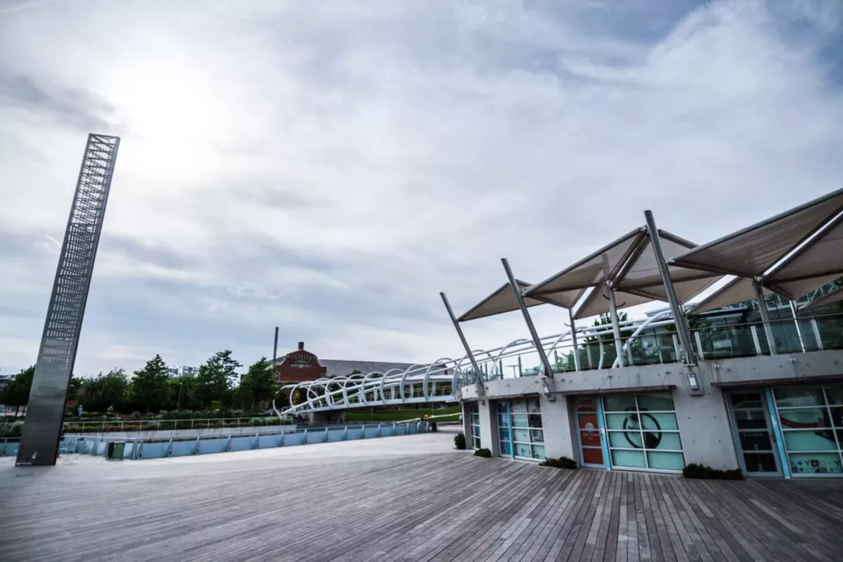 Riverfront pavilion with modern canopy and open public walkway.