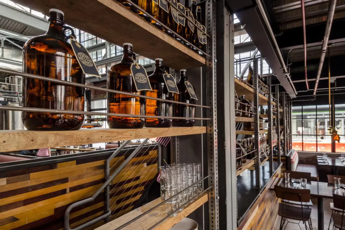 Restaurant interior with bar seating, wood finishes, and overhead lighting.