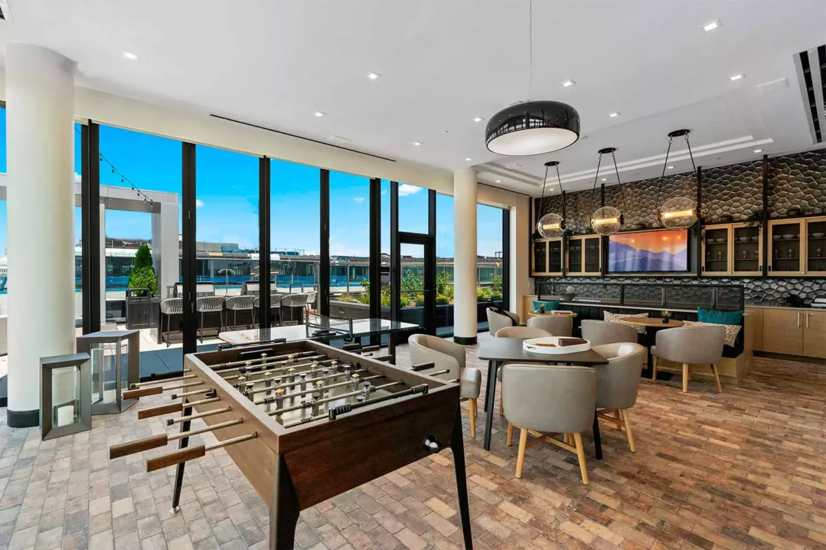 Spacious amenity lounge with dining table, lounge seating, and city views.