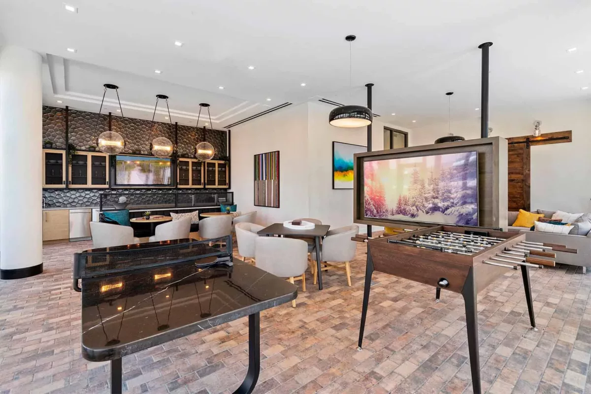 Entertainment lounge with bar seating, television, and expansive windows.