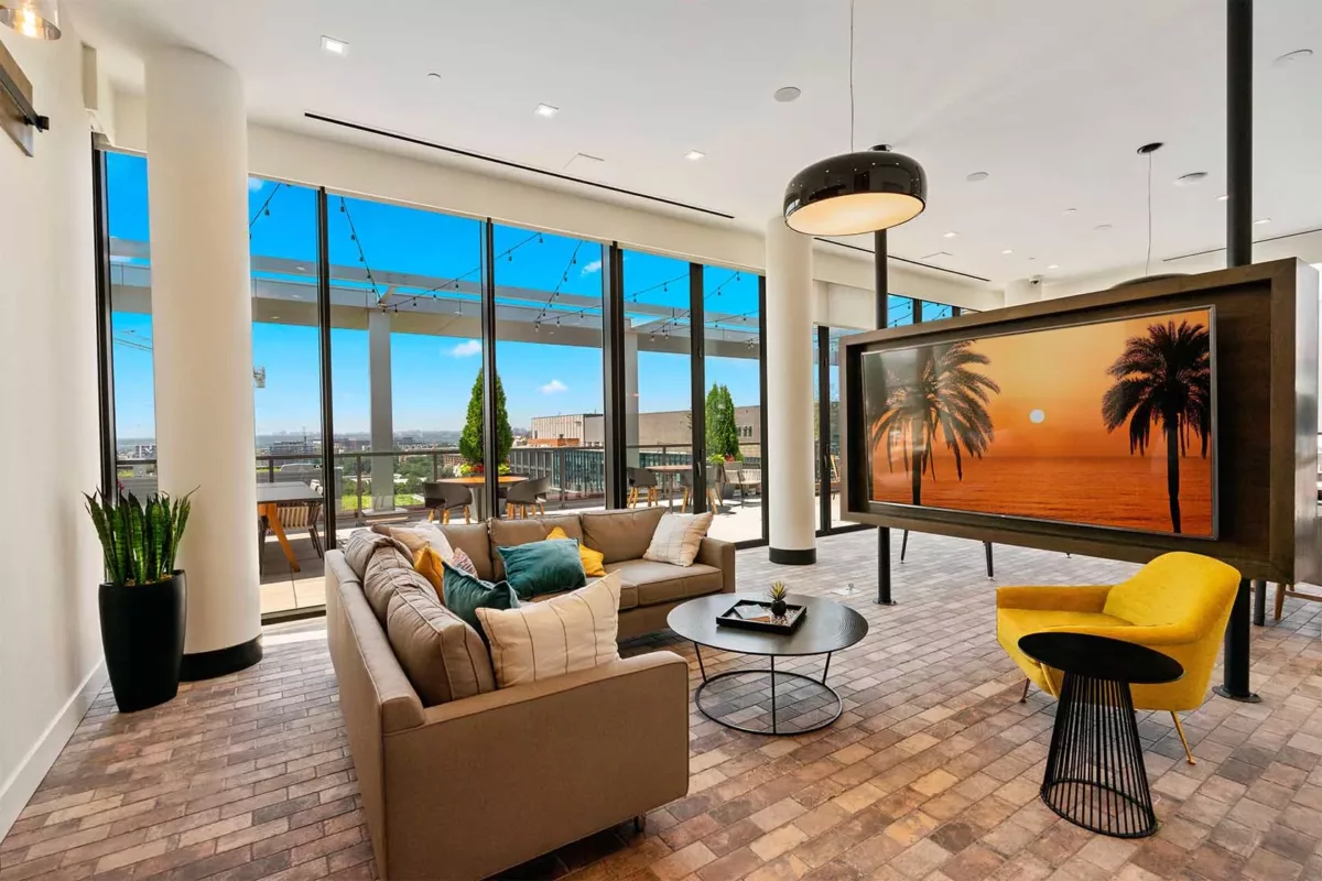 Corner lounge with sectional seating, accent chairs, and evening city views.