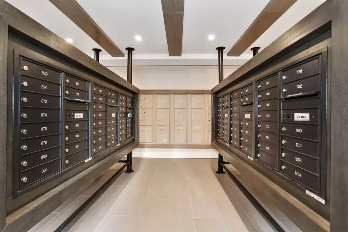 Secure mailroom with package lockers lining both walls and central walkway.