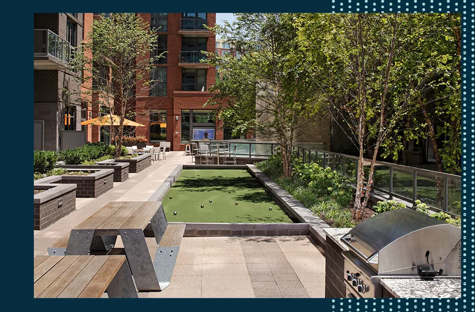 bocce court and outside courtyard at Parc Riverside apartments in Navy Yard DC with black frame that has teal polka dots on the right side