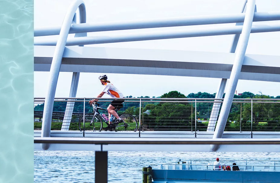 photo of woman riding bicycle across bridge at the Capitol Riverfront in Washington, DC